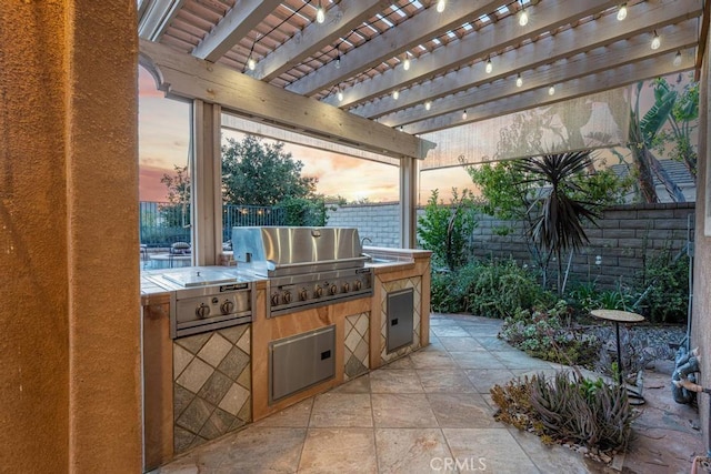 patio terrace at dusk featuring a pergola and area for grilling