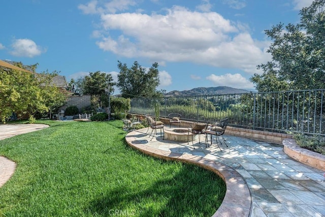 view of yard with a mountain view, a patio, and an outdoor fire pit