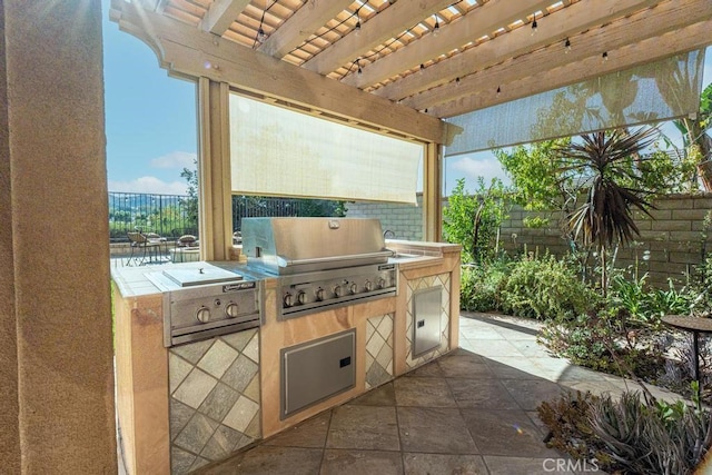 view of patio / terrace featuring a pergola, area for grilling, and exterior kitchen