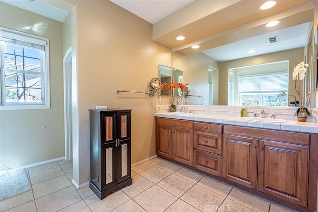 bathroom featuring tile patterned flooring, vanity, and a healthy amount of sunlight