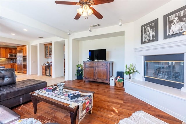 living room with wood-type flooring and ceiling fan