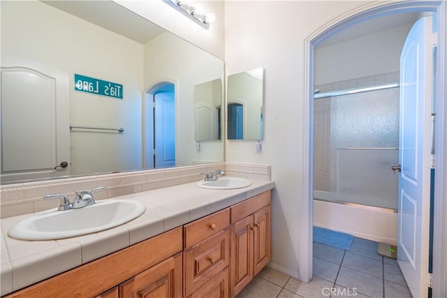 bathroom with tile patterned flooring, vanity, and bath / shower combo with glass door