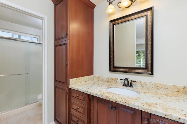 bathroom featuring vanity, a shower with door, toilet, and plenty of natural light