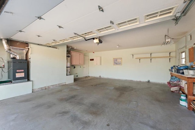 garage with strapped water heater, heating unit, and a garage door opener