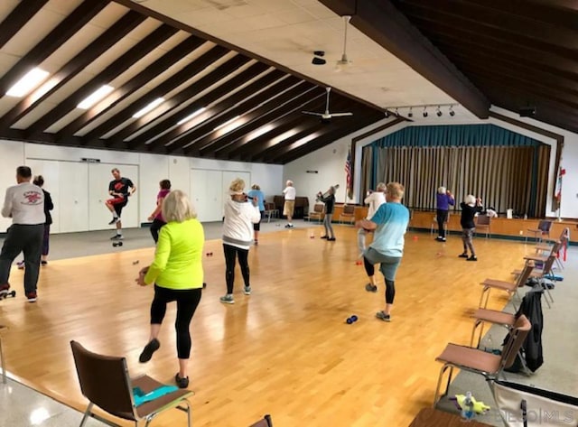 exercise room featuring vaulted ceiling and light wood-type flooring