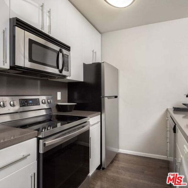 kitchen featuring dark hardwood / wood-style flooring, stainless steel appliances, and white cabinets