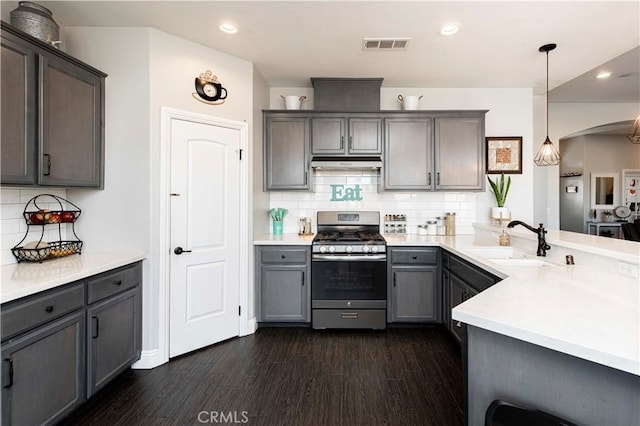 kitchen with sink, tasteful backsplash, decorative light fixtures, dark hardwood / wood-style flooring, and stainless steel range with gas stovetop