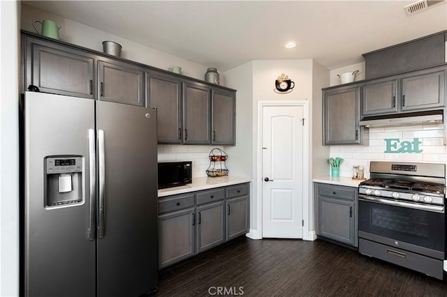 kitchen featuring dark hardwood / wood-style floors, decorative backsplash, and stainless steel appliances