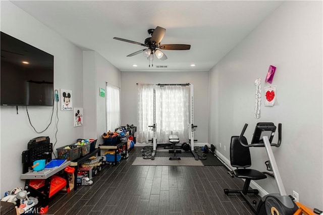 workout area with ceiling fan and dark wood-type flooring