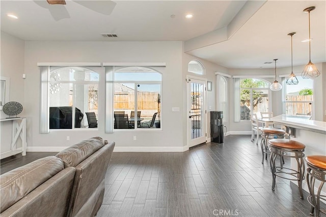 living room with ceiling fan and dark wood-type flooring