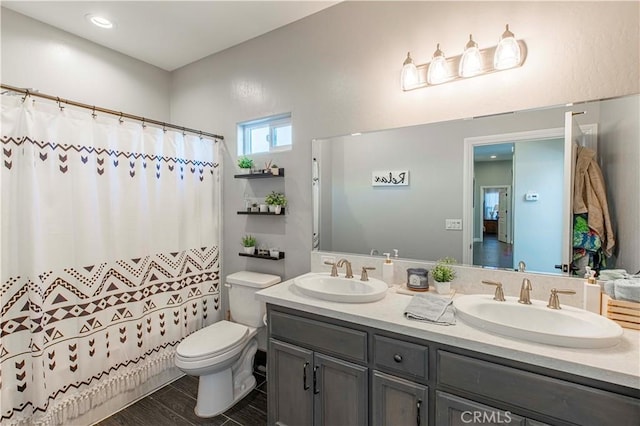 bathroom featuring vanity, curtained shower, and toilet