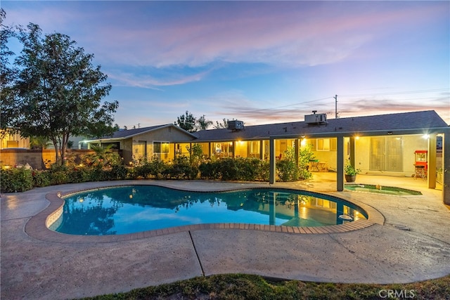 pool at dusk with a patio