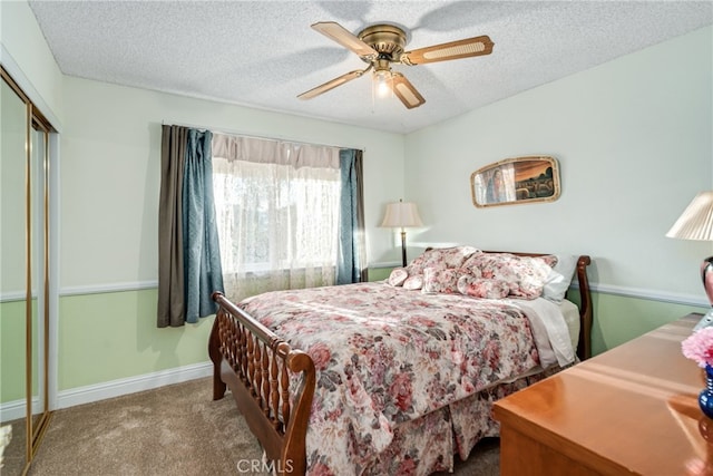 bedroom featuring carpet flooring, ceiling fan, a closet, and a textured ceiling