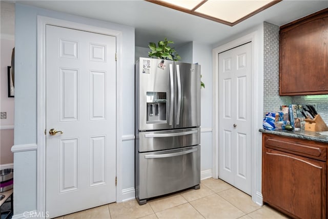 kitchen with backsplash, light tile patterned floors, and stainless steel fridge with ice dispenser