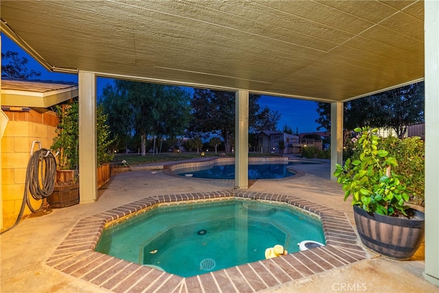 view of swimming pool featuring an in ground hot tub and a patio area