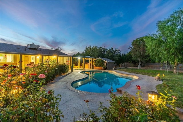 pool at dusk featuring a patio