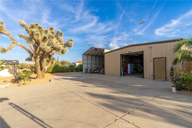 view of outdoor structure with a garage and a carport