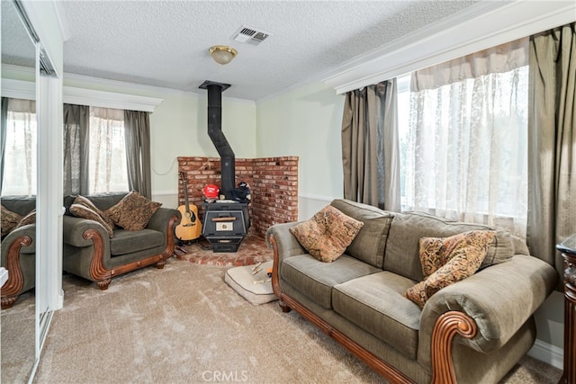 carpeted living room featuring ornamental molding, a textured ceiling, and a wood stove