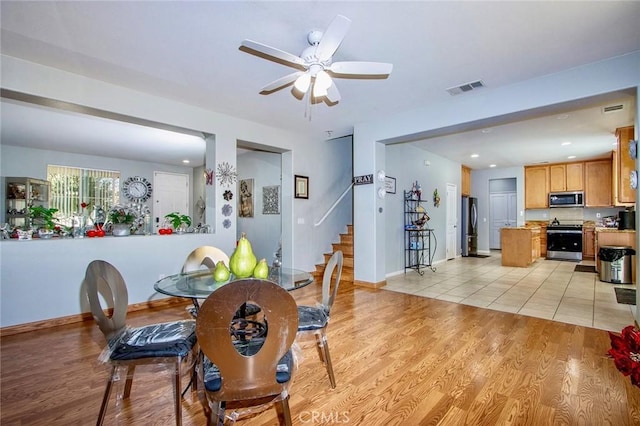 dining area with light wood-type flooring and ceiling fan