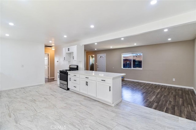 kitchen with gas stove, white cabinets, and light wood-type flooring