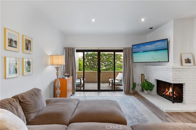 living room featuring a brick fireplace, french doors, and light hardwood / wood-style flooring