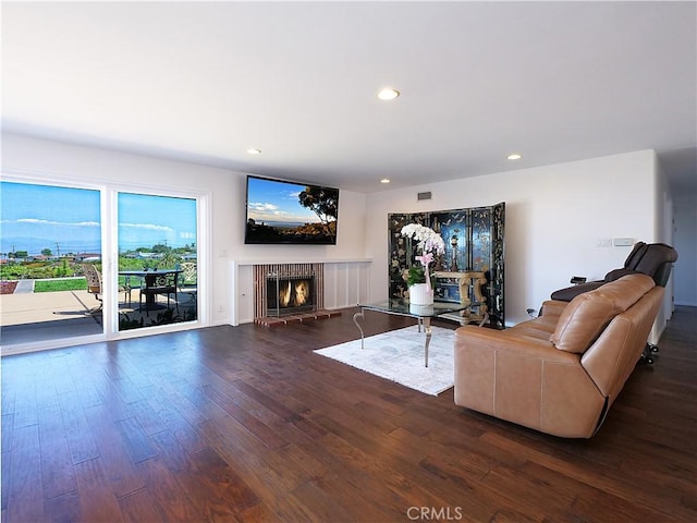 unfurnished living room with dark hardwood / wood-style flooring and a brick fireplace