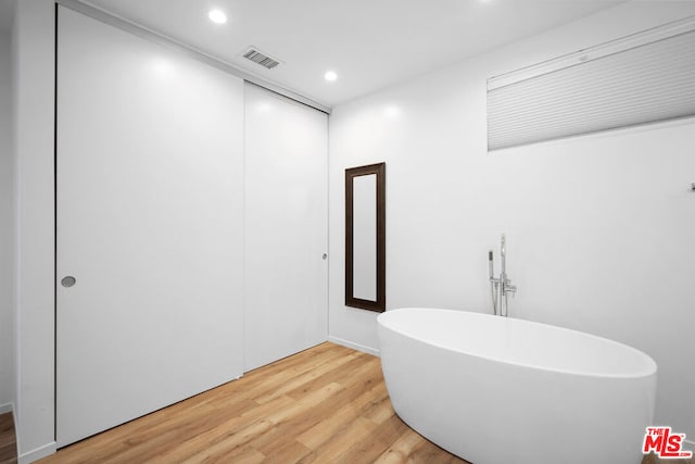 bathroom featuring hardwood / wood-style floors and a tub