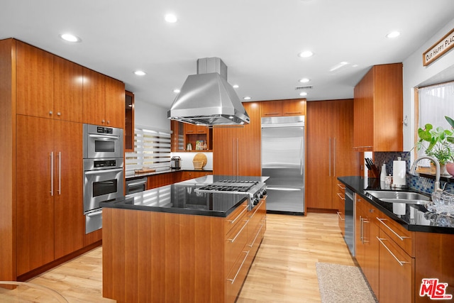 kitchen with island range hood, a center island, stainless steel appliances, and light wood-type flooring