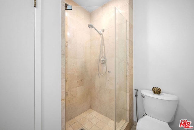 bathroom with a shower with door and toilet