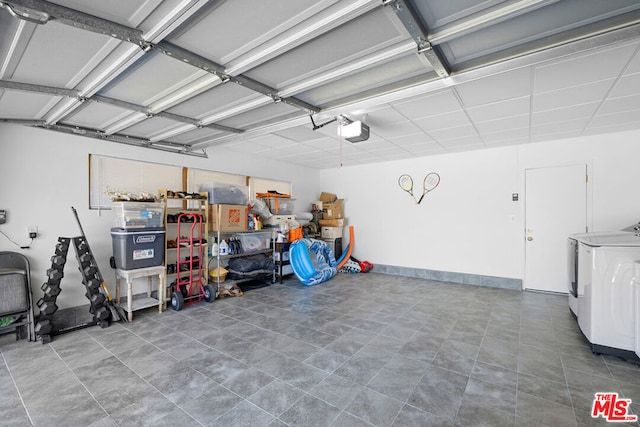 garage with separate washer and dryer and a garage door opener