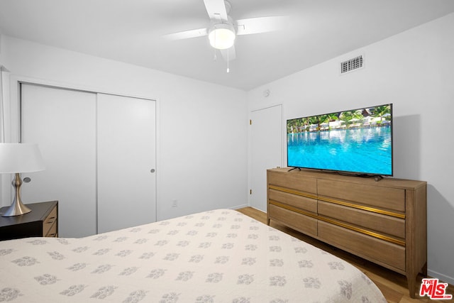 bedroom featuring ceiling fan, wood-type flooring, and a closet