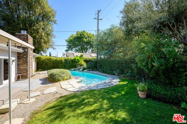 view of pool with a yard