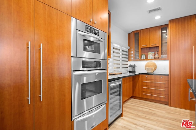 kitchen with light hardwood / wood-style flooring, wine cooler, and double oven