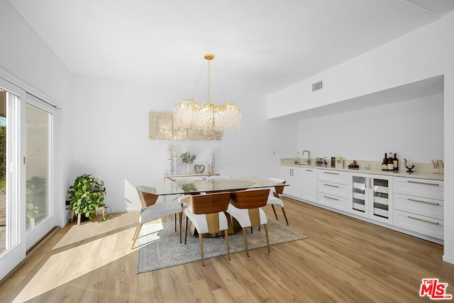 dining area featuring an inviting chandelier, light hardwood / wood-style flooring, and plenty of natural light