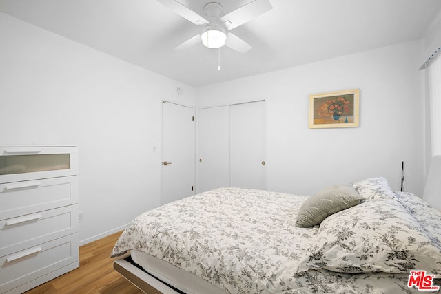 bedroom featuring a closet, light hardwood / wood-style flooring, and ceiling fan