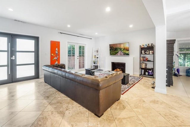 tiled living room with french doors and a healthy amount of sunlight