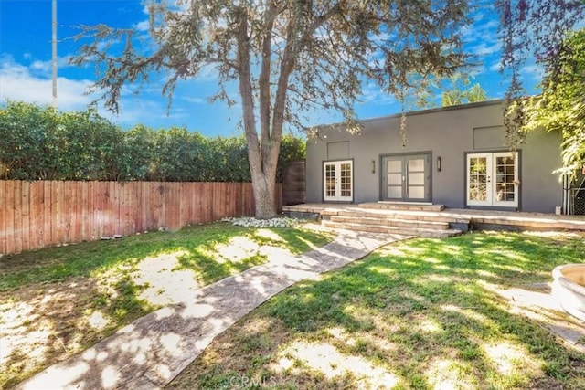 back of property with a yard and french doors