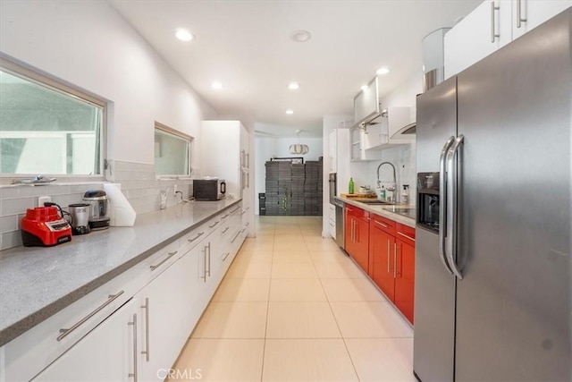 kitchen featuring backsplash, stainless steel appliances, white cabinetry, and sink