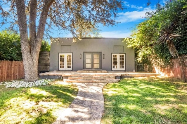 view of front of home featuring a front yard and french doors