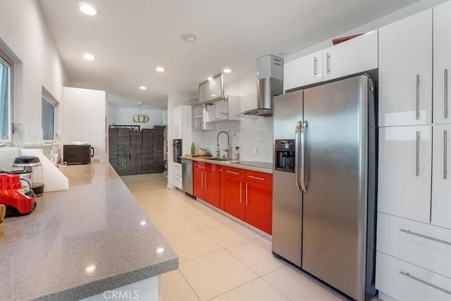 kitchen with wall chimney exhaust hood, white cabinetry, sink, and appliances with stainless steel finishes