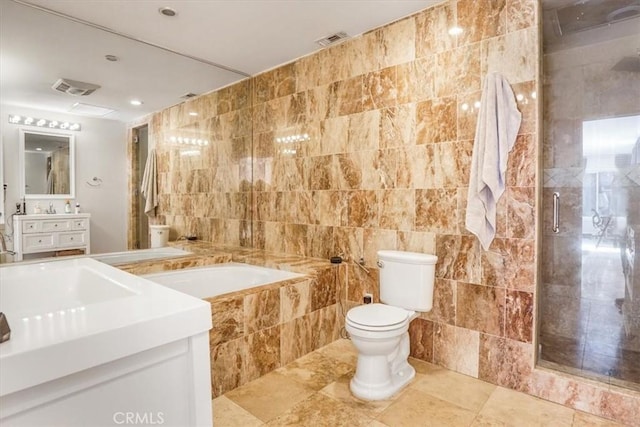 full bathroom with vanity, toilet, tile walls, and independent shower and bath