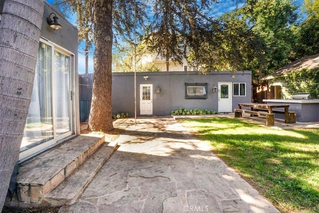 rear view of house with a lawn and a patio area