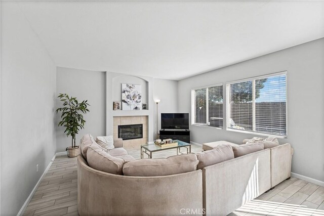 living room with a tile fireplace and light hardwood / wood-style floors