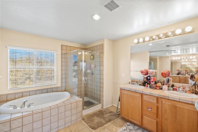 bathroom with tile patterned floors, separate shower and tub, and vanity