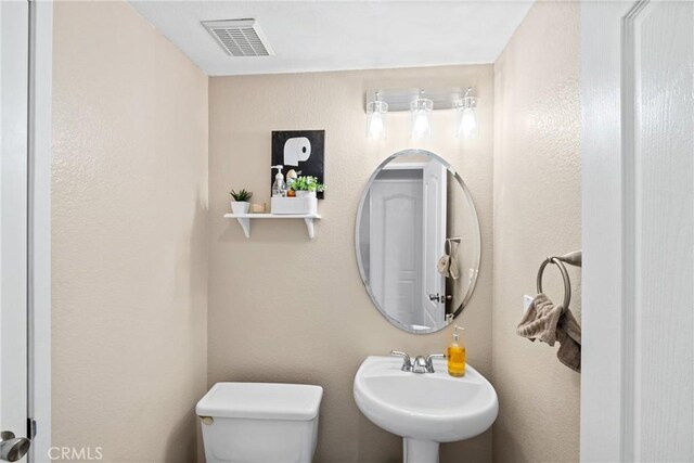 bathroom featuring toilet and sink