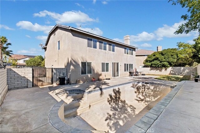 back of property featuring cooling unit, a patio area, and an empty pool