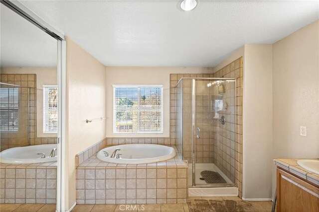 bathroom with tile patterned flooring, vanity, and independent shower and bath