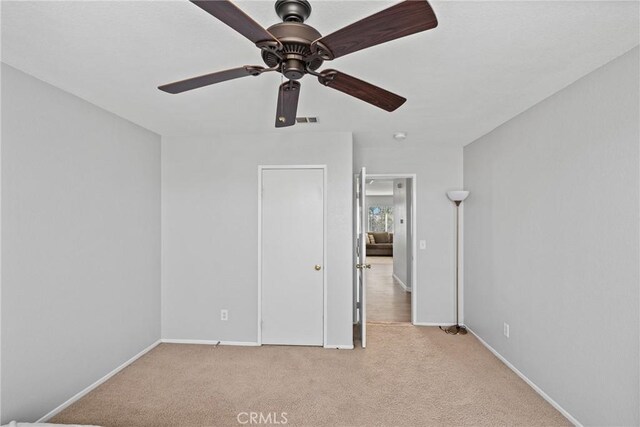 unfurnished bedroom featuring ceiling fan and light colored carpet