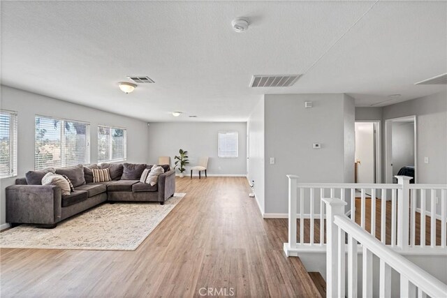 living room with wood-type flooring and a textured ceiling