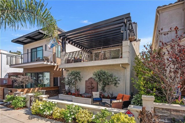 rear view of property with a balcony, a patio, an outdoor hangout area, and a pergola